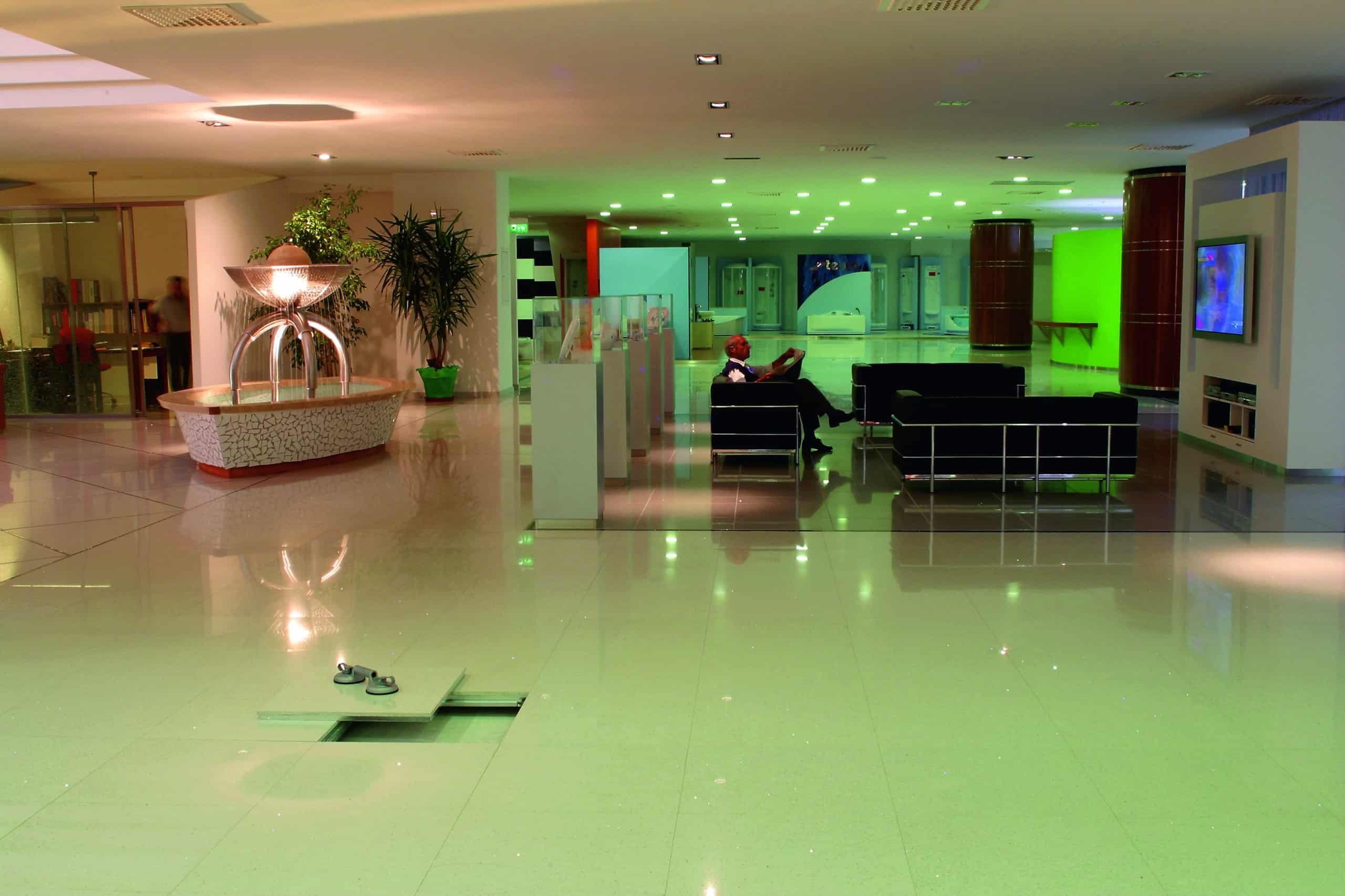 Intérieur spacieux et moderne avec des sols brillants, une fontaine centrale, des sièges lounge et une ambiance verte