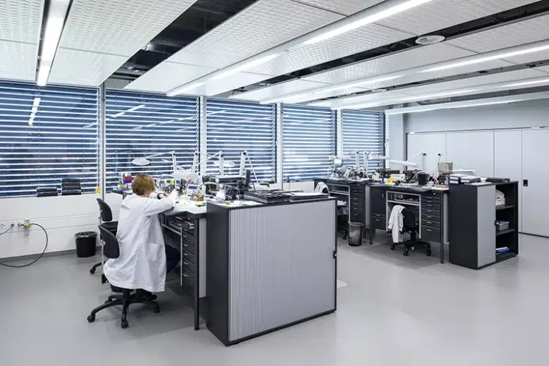 Un espace de recherche propre et lumineux avec plusieurs postes de travail, chacun équipé d'outils et d'appareils spécialisés, utilisé pour l'assemblage de précision