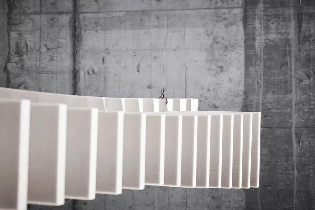 Gros plan sur des baffles acoustiques blancs suspendus &agrave; un plafond en b&eacute;ton pour l'absorption du bruit