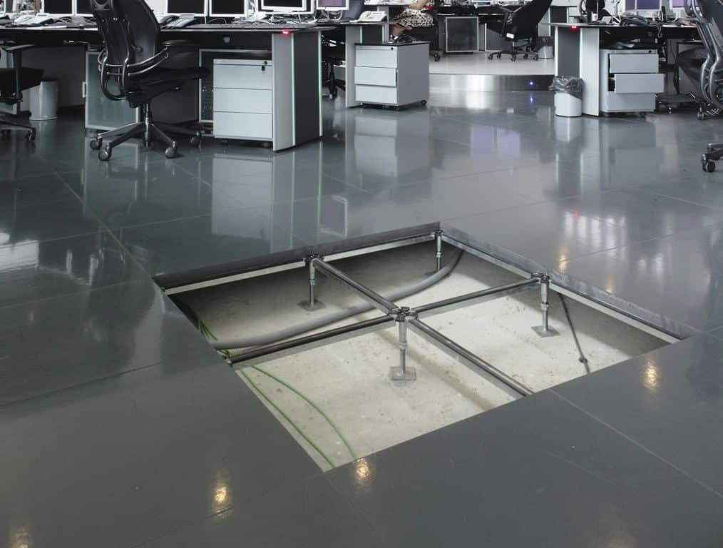 Espace de bureau avec plancher technique, montrant l'installation des câbles et la structure de support