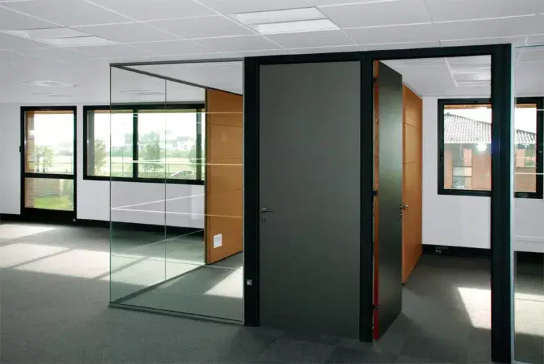 Un espace de bureau avec une porte noire et des cloisons vitrées transparentes, permettant à la lumière naturelle de circuler