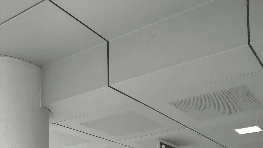 Plafond métallique avec éclairage intégré et panneaux perforés dans un design intérieur moderne