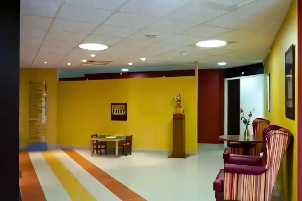 Hall d’entrée spacieux avec un éclairage chaleureux, un plafond suspendu avec des lumières circulaires et des sièges confortables