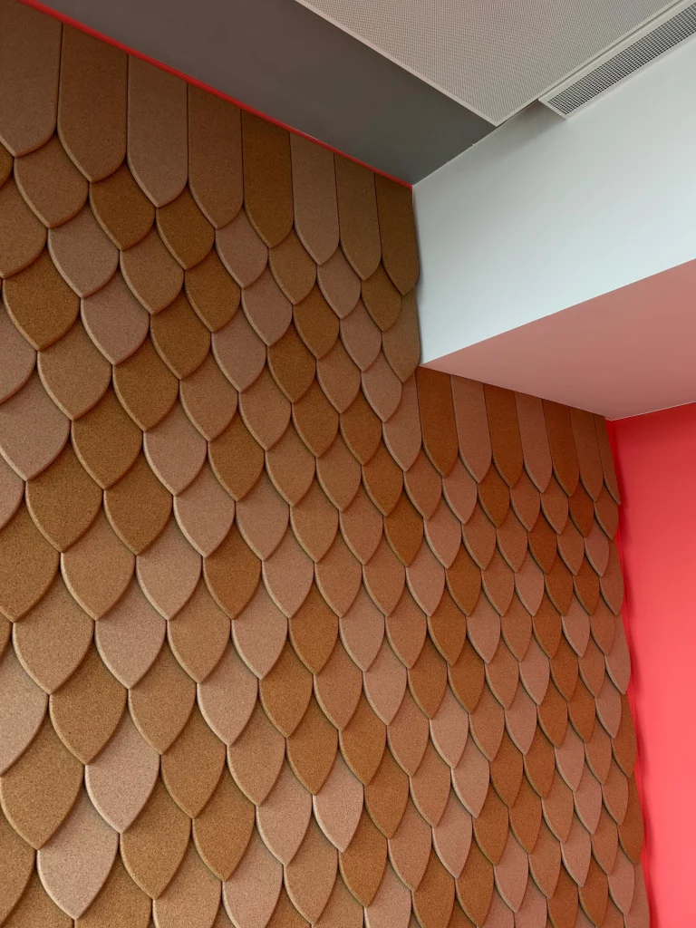 Gros plan sur des panneaux muraux acoustiques en li&egrave;ge avec motif en &eacute;caille dans un espace de bureau moderne