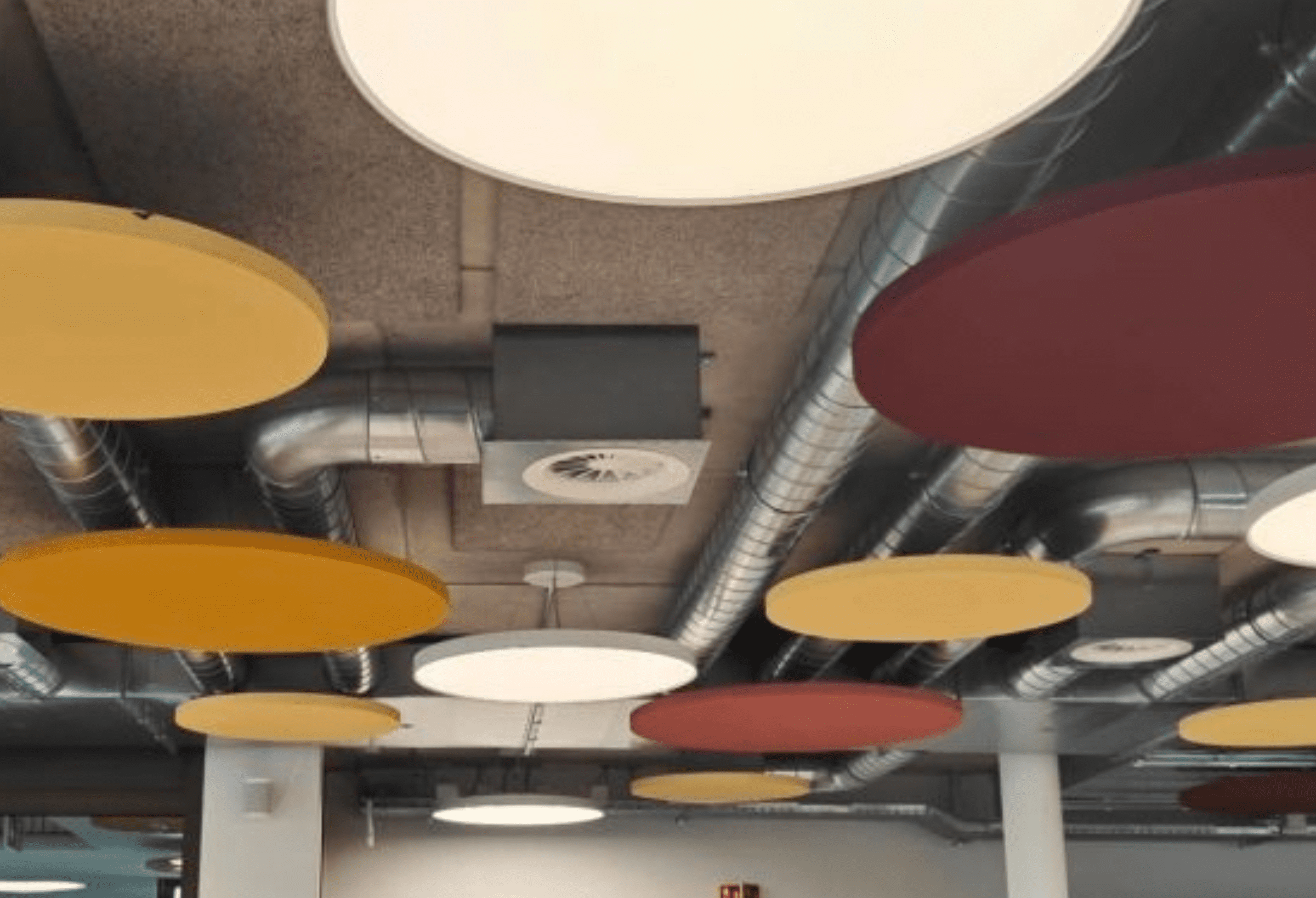 Panneaux acoustiques colorés au plafond de cafétéria bureau avec cloisons amovibles et mobilier moderne