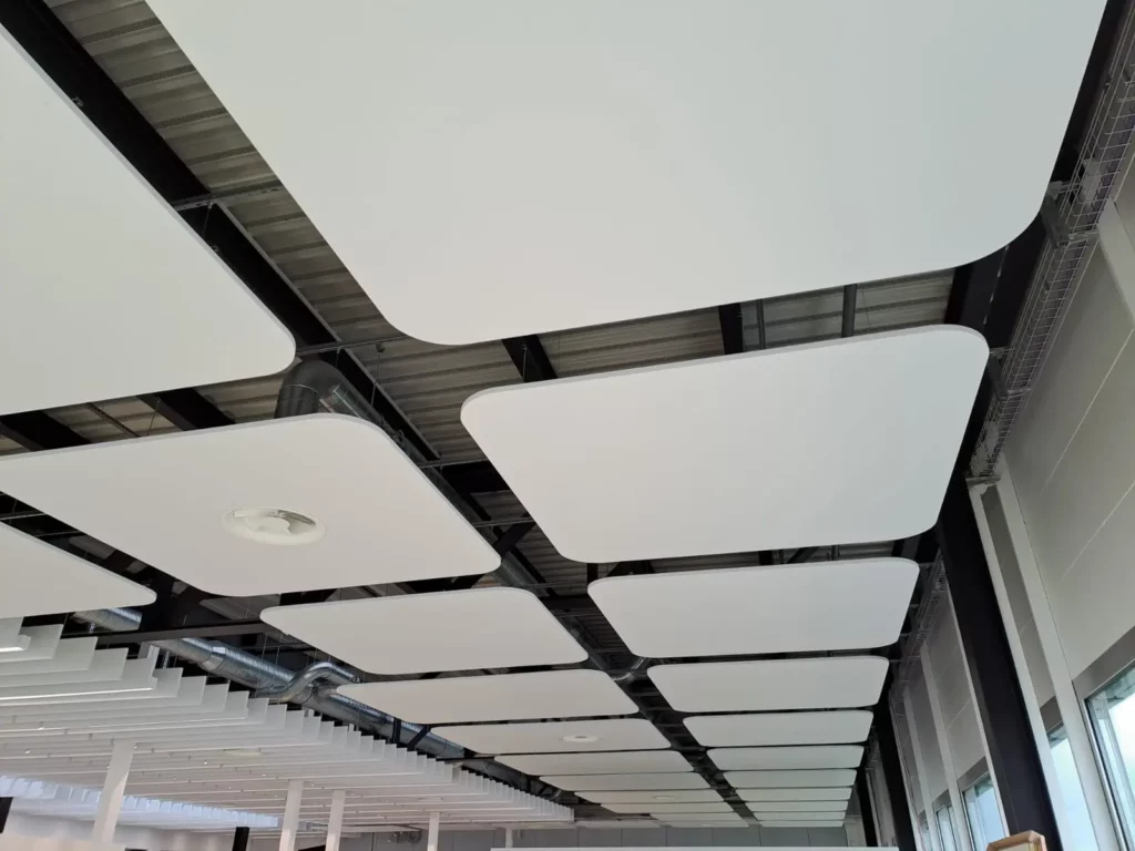 Baffles acoustiques suspendus au plafond avec éclairage intégré dans des bureaux modernes afin d’améliorer le confort sonore et la qualité de l’environnement de travail
