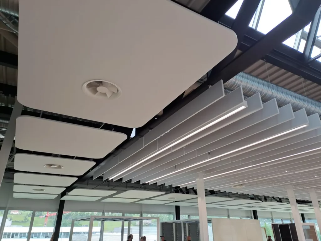 Plafond avec baffles acoustiques et ventilation intégrée dans des bureaux
