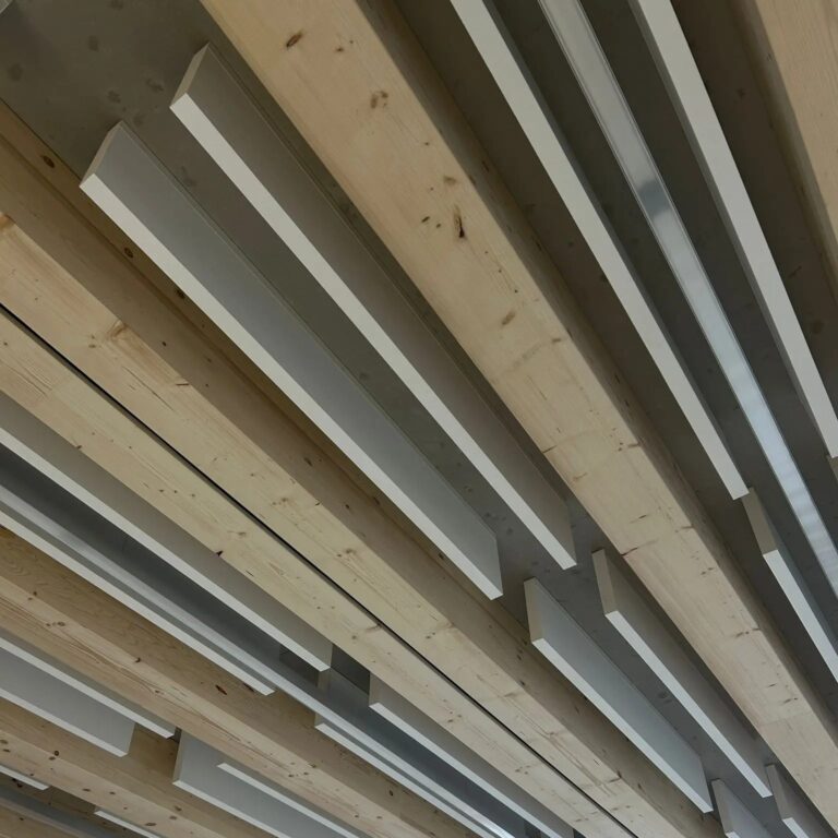 D&eacute;tail d&rsquo;&icirc;lots acoustiques int&eacute;gr&eacute;s dans des profil&eacute;s m&eacute;talliques en U au sein d&rsquo;un &eacute;tablissement scolaire &agrave; Gen&egrave;ve pour am&eacute;liorer les performances acoustiques des salles de classe.