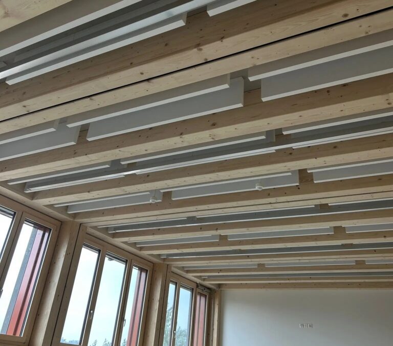 &Icirc;lots acoustiques int&eacute;gr&eacute;s entre les poutres en bois dans une salle de classe pour optimiser l&rsquo;absorption sonore et le confort d&rsquo;apprentissage.